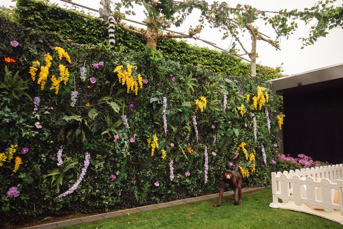 Groene bloemenwand met junglefiguren