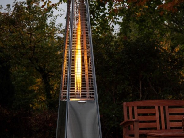 Rvs-piramide terrasheater met levende vlam op een terras