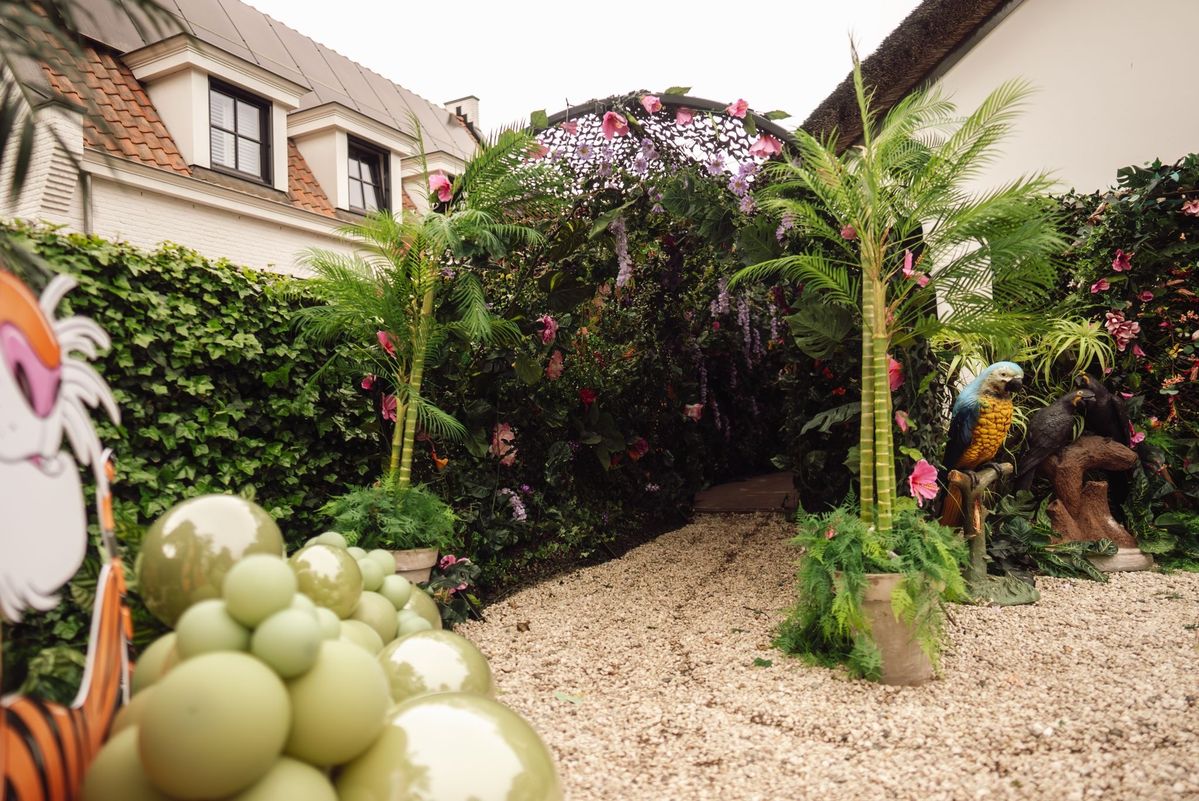 Bloemenboog met palmen en papegaai