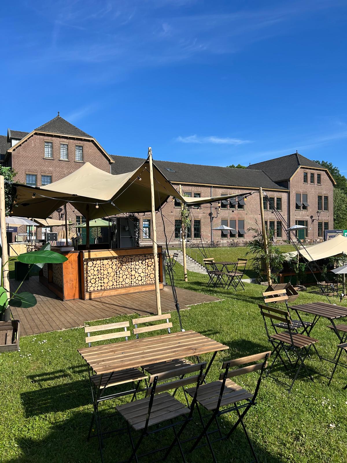 Houten bar met boomschijvendecor onder een stretchtent