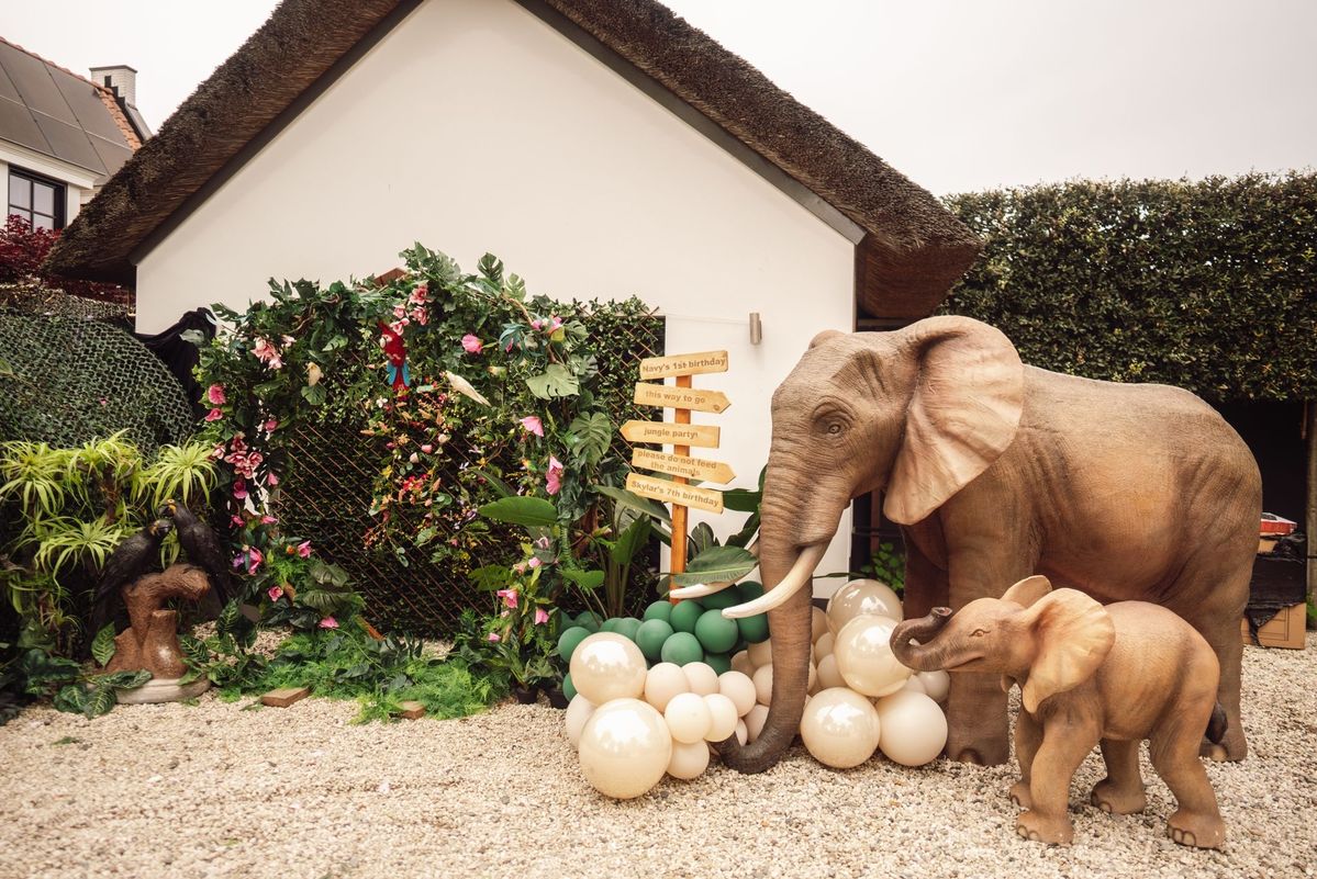 Olifantenbeelden met ballonnen en jungle-wegwijzer