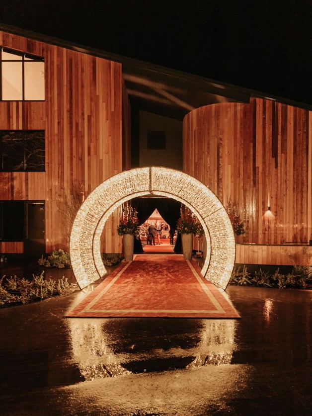 Verlichte architecturale boog als entree bij een avondevent