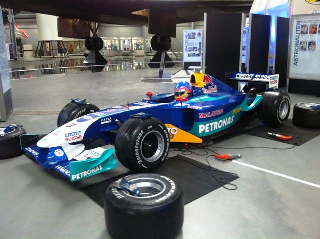 Blauwe formule 1-bolide met Petronas-livery als eyecatcher op een event