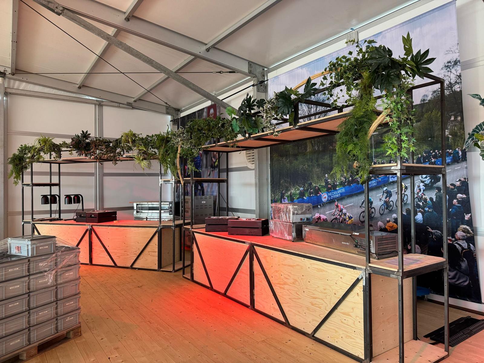 Maatwerk bar van hout en staal met groendecoratie in een tent